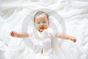 Cute newborn baby girl in white blanket onÂ nurseryÂ bed.Â AdorableÂ new born child, little boy eyes look people Family, new